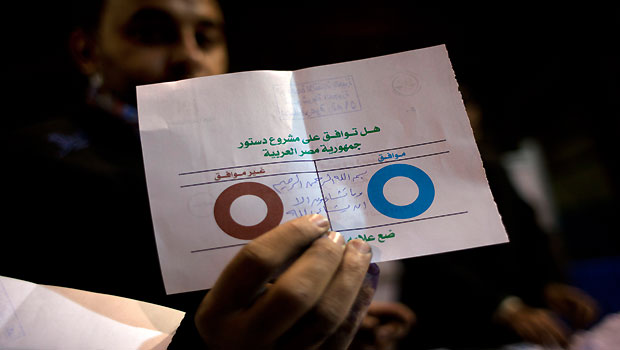 In this Saturday, Dec. 22, 2012 file photo, an Egyptian election worker shows his colleagues an invalid ballot while counting ballots at the end of the second round of a referendum on a disputed constitution drafted by Islamist supporters of president Mohammed Morsi at a polling station in Giza, Egypt. (AP)