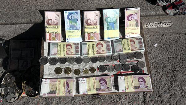 Iranian banknotes and foreign coins are displayed by a vendor on a side walk of the Ferdowsi Street in Tehran, Iran. (AP)