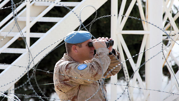 File dated November 24, 2008 shows a UN soldier looking through binoculars from an observation point near in the demilitarized United Nations Disengagement Observer Force (UNDOF) Zone in the Golan Heights. (AFP)