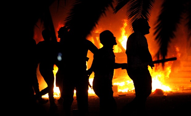  In this  Friday, September 21, 2012, file photo, Libyan civilians watch fires in the Ansar Al-Shari'a Brigades compound, after hundreds of Libyans, Libyan military and police raided the brigades' base in Benghazi, Libya. (AP Photo/Mohammad Hannon, File)