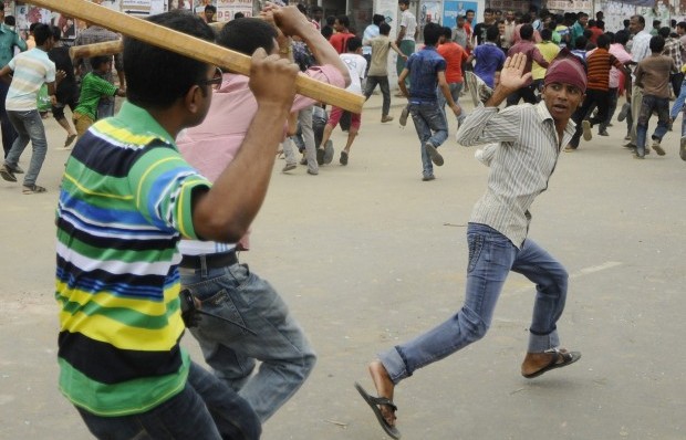 Plain-clothed Bangladeshi police brandish sticks as they attempt to break up demonstrating garment workers following the collapse of an eight-storey building, in Dhaka on April 26, 2013.  (AFP PHOTO/STR)