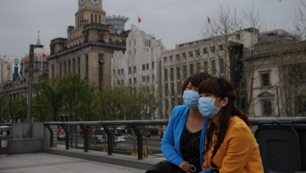 Women wear face masks as they visit the historic Bund in Shanghai on April 19, 2013. Source: AFP Photo/Peter Parks