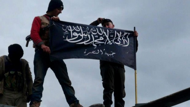 Rebels from Al-Qaida affiliated Jabhat al-Nusra waving their brigade flag on the top of a captured Syrian air force helicopter in Idlib province, northern Syria (AP Photo/Edlib News Network ENN, File)