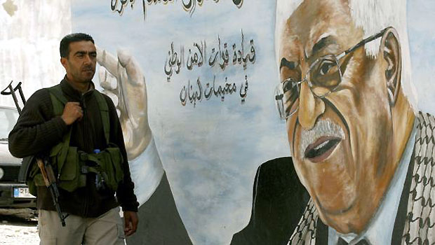 A Fatah movement member stands next to a mural of the Palestinian leader Mahmud Abbas in the Ain al-Helweh Palestinian refugee camp on the outskirts of the southern Lebanese city of Sidon. (AFP)