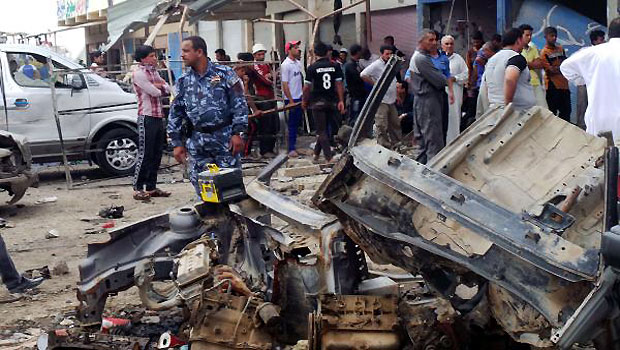 Iraqi security inspect the wreckage of a car bomb in the Aziziyah, south of the Iraqi capital on April 16, 2013, killing four people. (AFP)