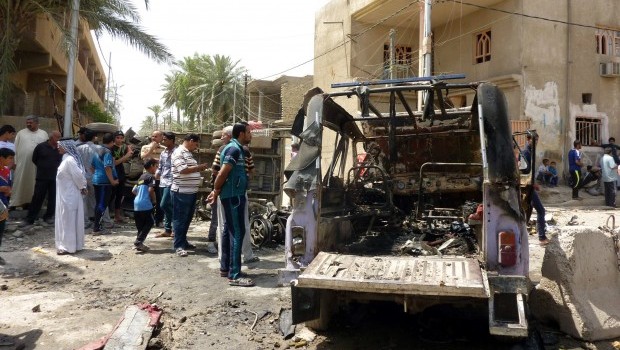 People look at the remains of vehicles damaged following an explosion in the al-Obaidi neighborhood, east of Baghdad on April 15, 2013. Source: AFP PHOTO/ALI AL-SAADI