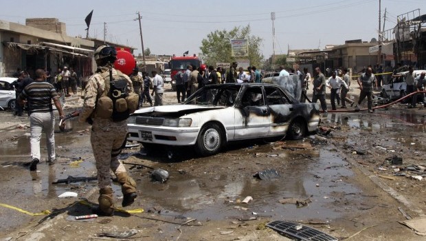 Civilians and security forces gather at the scene of a car bomb attack in the southern Shiite city of Karbala, 50 miles south of Baghdad, Iraq, on Monday, April 29, 2013. Five car bombs exploded Monday in predominantly Shi'ite cities and districts in central and southern Iraq, killing and wounding dozens of people, police said. (AP Photo)