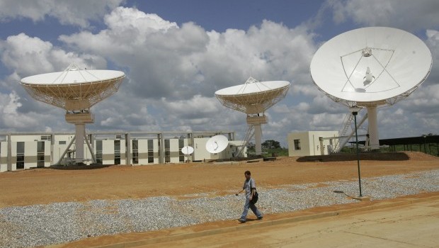 A man walks past a satellite dish station in this October 28, 2008 file photo. (AP Photo/Howard Yanes, File)