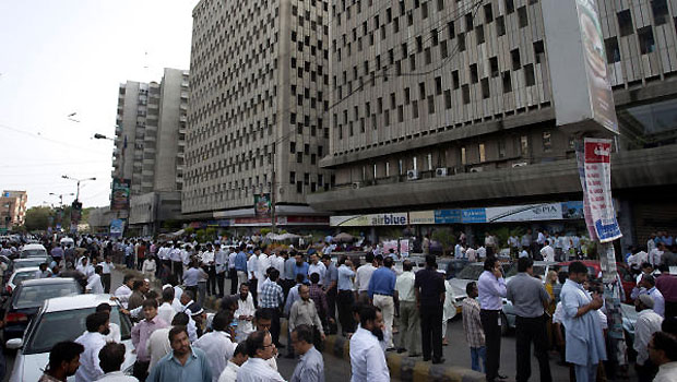 People evacuate buildings and gather on road after a tremor of an earthquake was felt in Karachi, Pakistan, Tuesday, April 16, 2013. (AP)