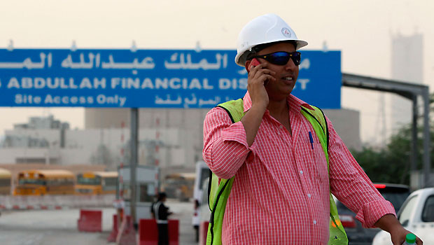 A worker talks on his phone near the King Abdullah Financial District, which is currently under construction, near King Fahad Road in the Asahafa area in Riyadh, April 23, 2013. (REUTERS/Faisal Al Nasser)