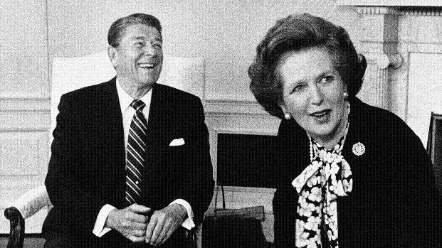 British Prime Minister Margaret Thatcher turns to look at the crush of photographers in the Oval Office as President Reagan laughs during a photo session at the White House in Washington in this February 20, 1985 file photo.  (AP Photo/Scott Applewhite, File)