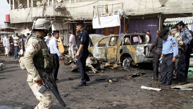 Iraqi security force members and civilians gather at the site of a car bomb attack in front of a crowded popular restaurant in Basra, 340 miles (550 kilometers) southeast of Baghdad, Iraq, Monday, May 20, 2013 (AP Photo/ Nabil al-Jurani)