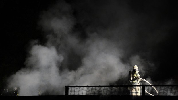Firemen extinguish a blaze at a nursery school in the Stockholm suburb of Kista after youths rioted in several different suburbs around Stockholm, Sweden for a fourth consecutive night on May 24, 2013. (AFP/Jonathan Nackstand)