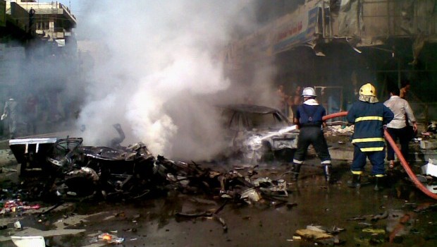 Iraqi firefighters distinguish a fire at the scene of a car bomb attack in Baghdad, Iraq, Monday, May 27, 2013. A parked car bomb explosion in the busy commercial Sadoun Street in central Baghdad, killed and wounded scores of people, police said. (AP Photo)