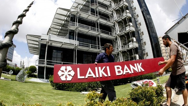 Workers take down the insignia from the headquarters of Cyprus now defunct second-largest bank Laiki in capital Nicosia, Cyprus, Wednesday, May 15, 2013. Source: AP Photo/Philippos Christou