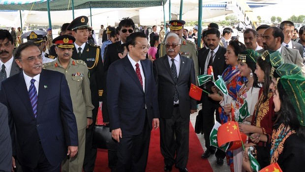 Chinese Premier Li Keqiang (center), flanked by Pakistani President Asif Ali Zardari (left) and caretaker premier Mir Hazar Khan Khoso (center right) is welcomed by hostesses bearing Chinese flags upon his arrival at Pakistan's Nur Khan air base in Rawalpindi on May 22, 2013. Source: AFP Photo/STR