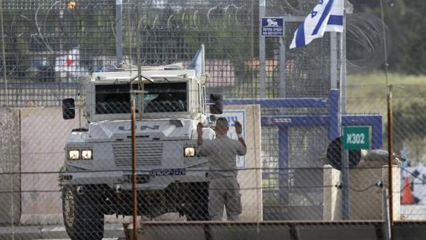 United Nations peacekeeper directs an armoured vehicle after it crossed from Syria to the Israeli-occupied Golan Heights at the Kuneitra border crossing May 8, 2013. (REUTERS/Baz Ratner)