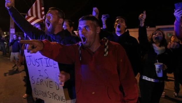 Local residents protest outside Dyer-Lake Funeral Home, where they believe deceased Boston Marathon bombing suspect Tsarnaev's body is being held, as police leave funeral home in North Attleborough. (REUTERS)