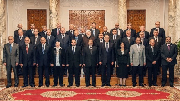 A handout photograph released by the Egyptian Presidency shows Egyptian president Mohamed Morsi (C) posing for a group photograph with his prime minister, Hisham Qandil (5-L), and nine new ministers during a meeting in Cairo. (EPA/EGYPTIAN PRESIDENCY/HANDOUT)