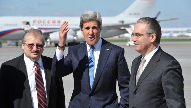 US secretary of state John Kerry, center, gestures next to Yuri Filatov, right, of the Russian Foreign Ministry and Alexandr Darchiyev of the Russian Foreign Ministry North American Department after Kerry's arrival at Moscow Vnukovo Airport on Tuesday, May 7, 2013. (AP Photo/ Mladen Antonov, pool)