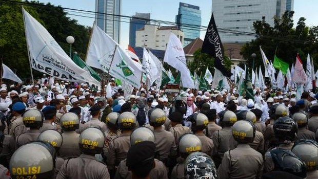 A phalanx of Indonesian police (foreground) block members of an Islamic hardline group belonging to the Islamic Defenders Front (FPI) from marching in front of the Myanmar embassy during a rally in Jakarta on May 3, 2013. (AFP Photo) 