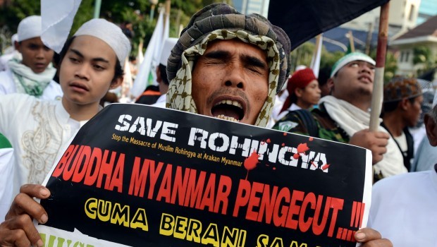 A protester belonging to the hardline Islamic Defenders Front (FPI) holds a placard calling to "stop the massacre of Muslim Rohingya and Myanmar Buddhists cowards" during a rally near at the Myanmar embassy in Jakarta on May 3, 2013. Source: AFP Photo/Romeo Gacad