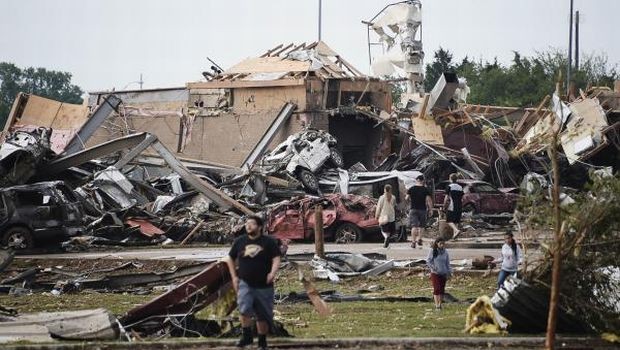 People walk near destroyed buildings and vehicles after a tornado struck Moore, Oklahoma, near Oklahoma City, May 20, 2013. (REUTERS/Gene Blevins) 