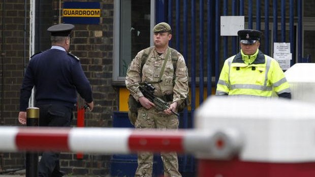 An armed soldier stands guard at the gate of the Royal Artillery Barracks near the scene of a terror attack in Woolwich, southeast London, Thursday, May 23, 2013. (AP Photo/Sang Tan)