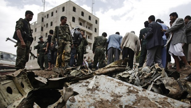 A plane wreck are seen on the ground as security forces and soldiers gather at the site of a plane crash in Sanaa, Yemen, Monday 13, 2013. Source: AP Photo/Hani Mohammed