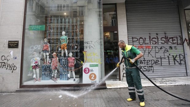 A municipal worker cleans streets in front of a damaged shop after clashes between protesters and riot police during a rally against Prime Minister Recep Tayyip Erdogan's government, in Istanbul, Turkey, 02 June 2013