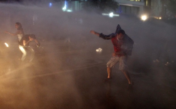 Anti-government protesters run to take cover to protect themselves from water cannons and tear gas as riot police disperse them during a protest in Ankara June 5, 2013. (Reuters/Umit Bektas)