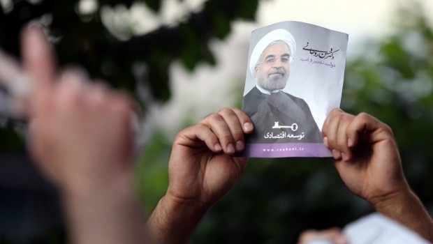  A supporter of newly elected President Hassan Rowhani as holds a poster depicting him during street festivities  after the official announcement of his victory, in Tehran, Iran, 15 June 2013 (EPA/ABEDIN TAHERKENAREH)