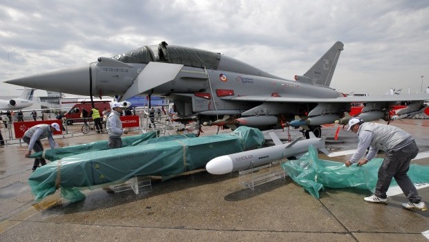 An employee removes the rain protection from items in front of a Eurofighter Typhoon during the first day of the 50th Paris Air Show at Le Bourget airport, north of Paris, Monday, June 17, 2013. The manufacturer, BAE, is hoping to secure an order for the jet from the air force of the United Arab Emirates (AP Photo/Francois Mori)