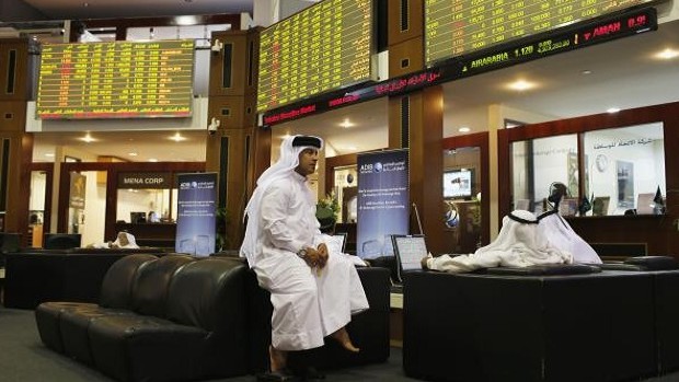 An investor monitors an electronic board displaying stock information at the Dubai Financial Market June 13, 2013. REUTERS/Ahmed Jadallah