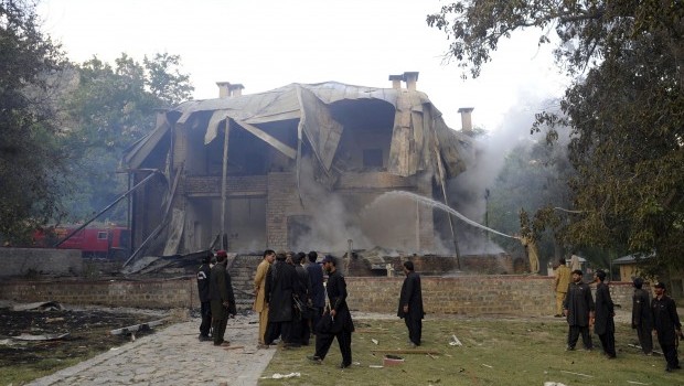 Pakistani security personnel look on as firefighters extinguish a blaze which gutted a historical building in Ziarat, 80 kilometres southeast of Quetta, on June 15, 2013. Source: AFP Photo/Banaras Khan