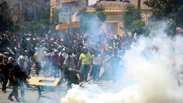 Radical Islamist movement Ansar al-Shariah supporters clash with Tunisian police officers after Tunisia's Interior Ministry on Friday. (AP Photo/Nawfel)