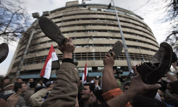 File photo of Egyptian protesters brandishing their shoes outside Maspero television building in Cairo. (AFP)