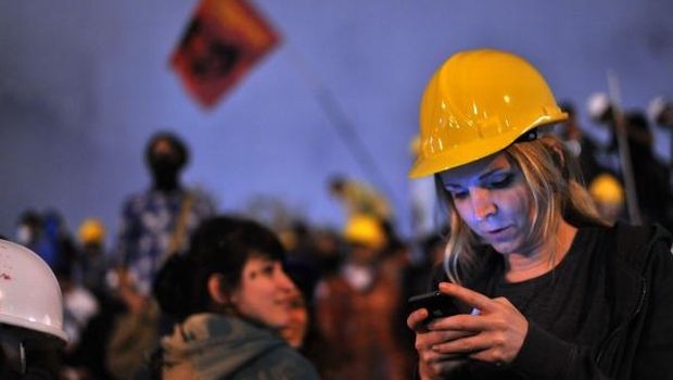  Turkish woman using a mobile phone to read the news on social media joins demonstrators at midnight in Taksim Gezi Park on June 13, 2013 in Istanbul. (AFP PHOTO/OZAN KOSE)