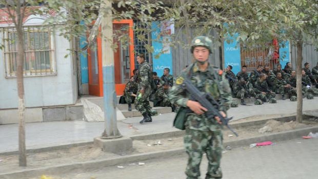 In this June 27, 2013 photo, an armed police officer stands guard in Lukqun township, Xinjiang, China. (AP Photo/Kyodo News)