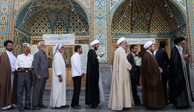 Men wait in line at a polling station to vote during presidential elections in Qom, 125 kilometers (78 miles) south of the capital Tehran, Iran, Friday, June 14, 2013. (AP Photo/Ebrahim Noroozi)