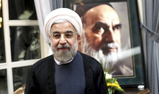 Iranian President elect Hasan Rouhani, stands in front of a portrait of the late revolutionary founder Ayatollah Khomeini, during visit of his shrine, just outside Tehran, Iran, Sunday, June 16, 2013. .(AP Photo/Ebrahim Noroozi)