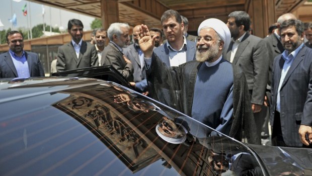 In this photo released by the official website of the office of Iranian President-elect Hasan Rouhani, Rouhani waves as he leaves a conference in Tehran, Iran, Saturday, June 29, 2013. (AP Photo/Office of the President-elect, Hojjat Sepahvand)