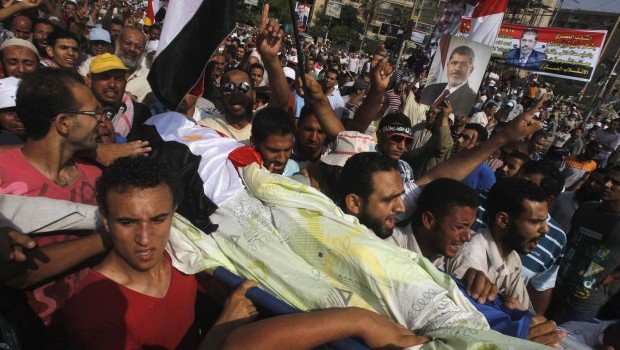 Supporters of Egypt's deposed President Mohamed Mursi carry the body of a fellow supporter killed by violence outside the Republican Guard headquarters in Cairo July 8, 2013 (REUTERS/Khaled Abdullah)