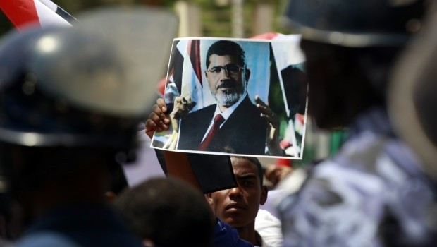 A protester holds a picture of deposed Egyptian President Mohamed Mursi as Sudanese and Egyptian Islamists shout slogans against Mursi's ousting during a rally after midday prayers, while they march from King Farouq Mosque to the Egyptian embassy in central Khartoum July 8, 2013. Source: Reuters/Mohamed Nureldin Abdallah
