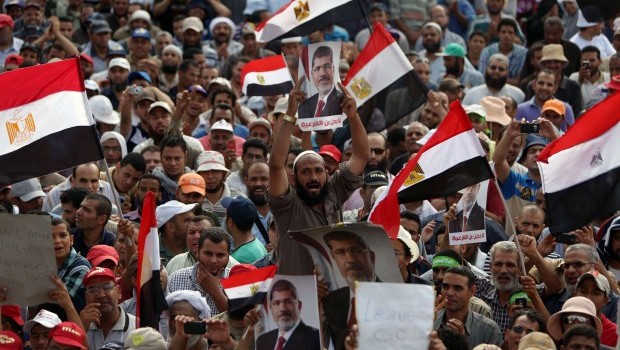 Supporters of deposed Egyptian president Mohamed Morsi hold portraits of him and  national flags during a rally on July 9, 2013 outside Cairo's Rabaa al-Adawiya mosque (AFP PHOTO / MAHMUD HAMS)