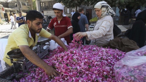 People buy rose petals on the first day of Ramadan, the holiest month in the Islamic calendar, at the Karaj Al-Hajez crossing, a passageway separating Aleppo's Bustan al-Qasr, which is under the rebels' control and Al-Masharqa neighborhood, an area controlled by the regime, July 10, 2013. (REUTERS/Muzaffar Salman)