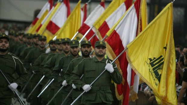 A picture taken on November 11, 2009, shows Hezbollah fighters, holding up Lebanese flags and the yellow flag of the militant Shiite Muslim group, as they parade on the occasion of Martyr's Day in the southern suburbs of Beirut. (AFP PHOTO/RAMZI HAIDAR)