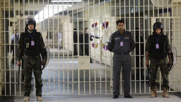 In this Feb. 21, 2009 file photo, guards stand at a cell block at the renovated Abu Ghraib prison, now renamed Baghdad Central Prison and run by Iraqis in Baghdad, Iraq. Late-night jailbreak attempts at two major prisons outside Baghdad have killed dozens, including at least 25 members of Iraqs security forces who battled militants armed with car bombs, mortars and machine guns, officials said Monday. (AP Photo/Karim Kadim, File)