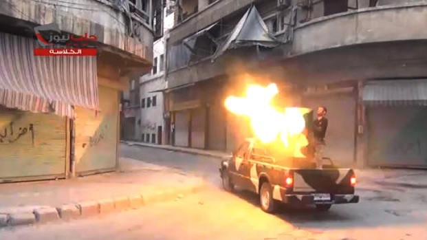 Fighters from the Free Syrian Army target one of the bastions of the regime’s forces in Aleppo, Syria, Monday July 22, 2013. Logo reads, "Aleppo News – Al-Kalasa." (AP Photo/Shaam News Network via AP video)