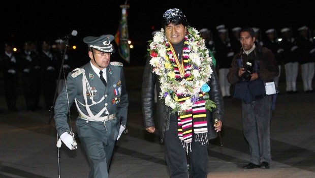 Bolivia's President Evo Morales (C), heavily garlanded as he reviews an honour guard on his arrival at El Alto airport in La Paz, Bolivia, late 03 July 2013. Source: EPA/Martin Alipaz